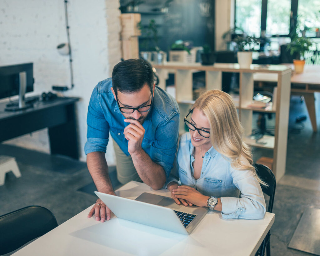 Confident young man and woman working together in creative office