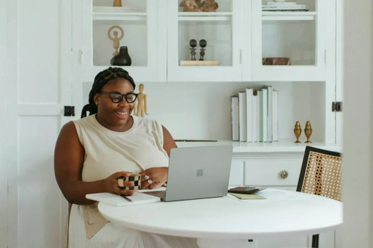 a woman sitting at a table with a laptop filing Form 8992