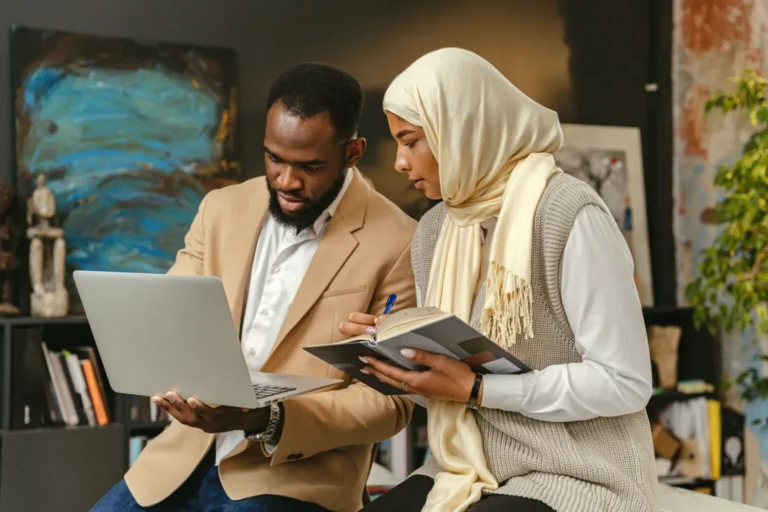 A man and woman looking at Form 112-w on a laptop