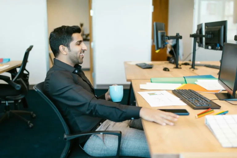 a man sitting at a desk with a cup of coffee